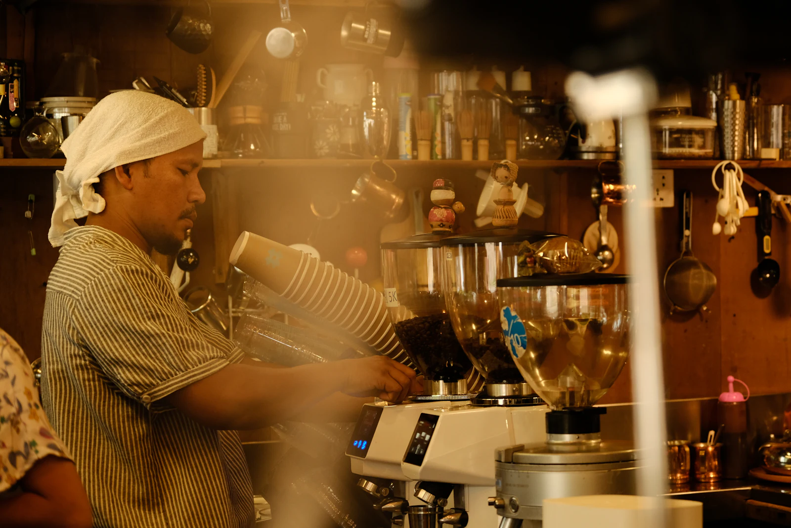 A barista working an espresso machine in a small independent coffee shop in Siem Reap, Cambodia.